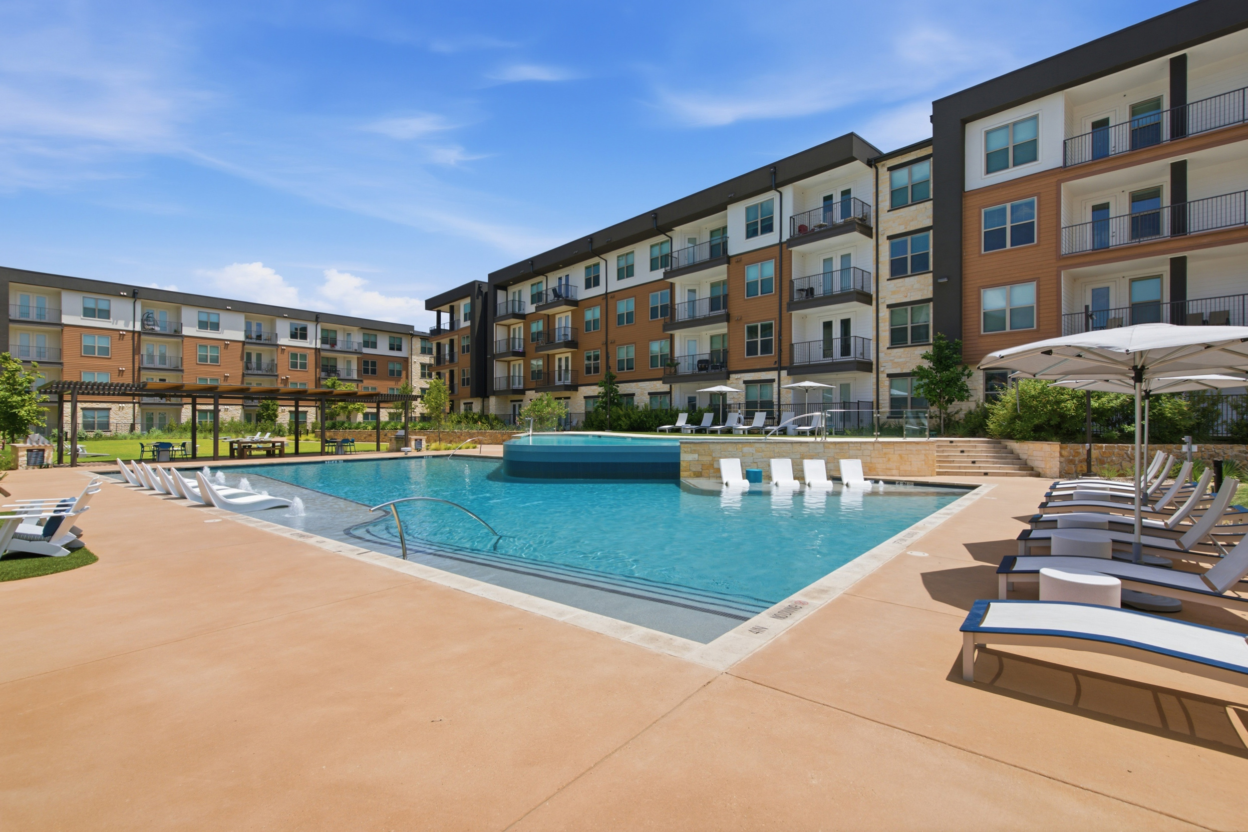 apartment pool with lounge chairs on pool deck